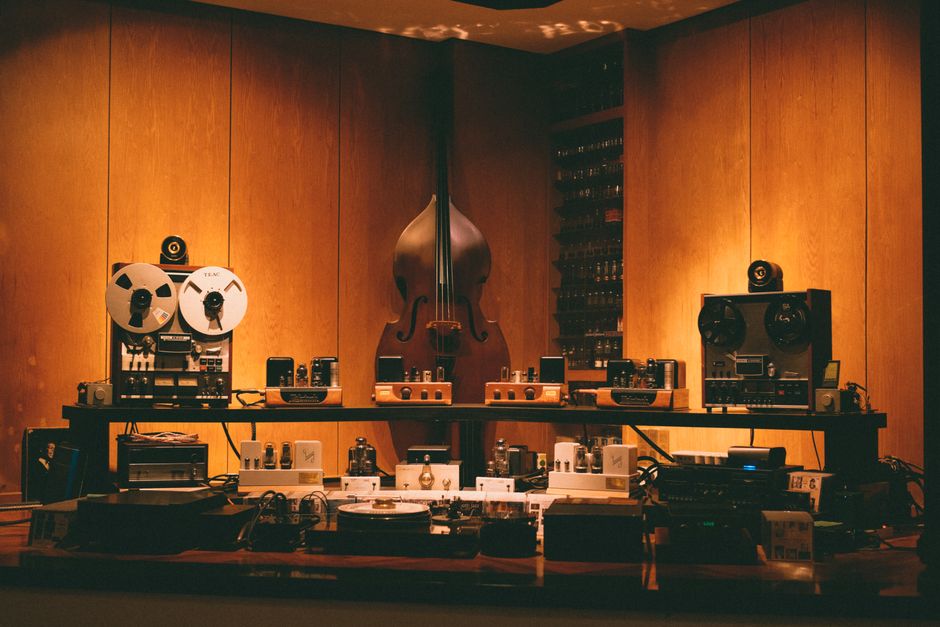 A retro-themed room featuring vintage audio equipment and a double bass. Perfect for music lovers.