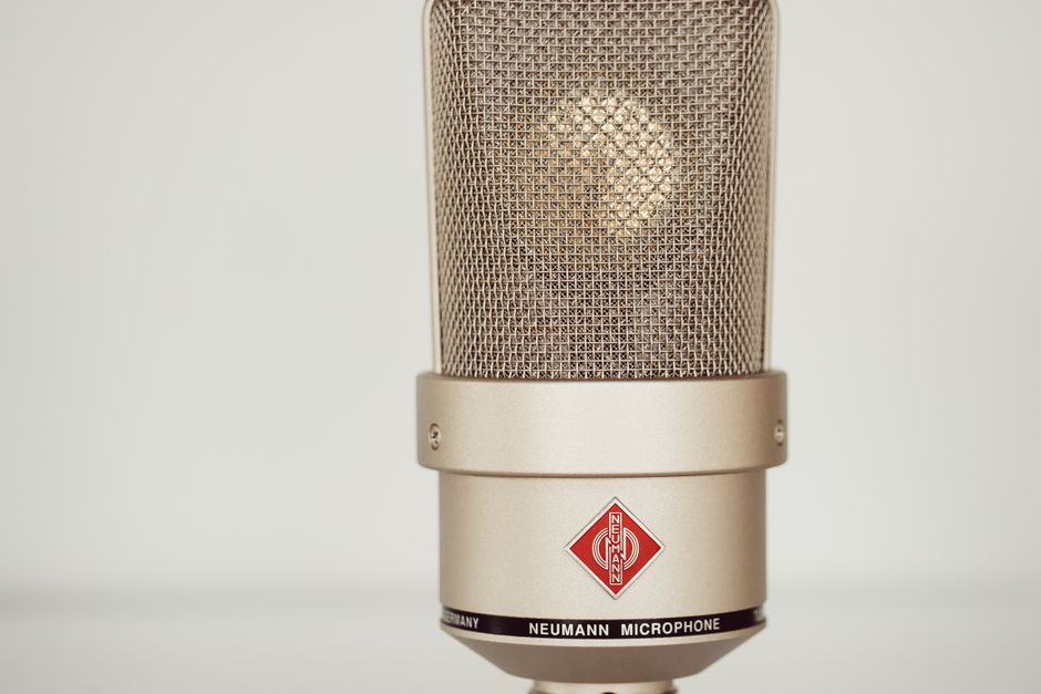 Close-up image of a vintage Neumann condenser microphone showcasing its metallic design.